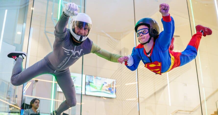 Niños volando como superhéroes en túnel de viento